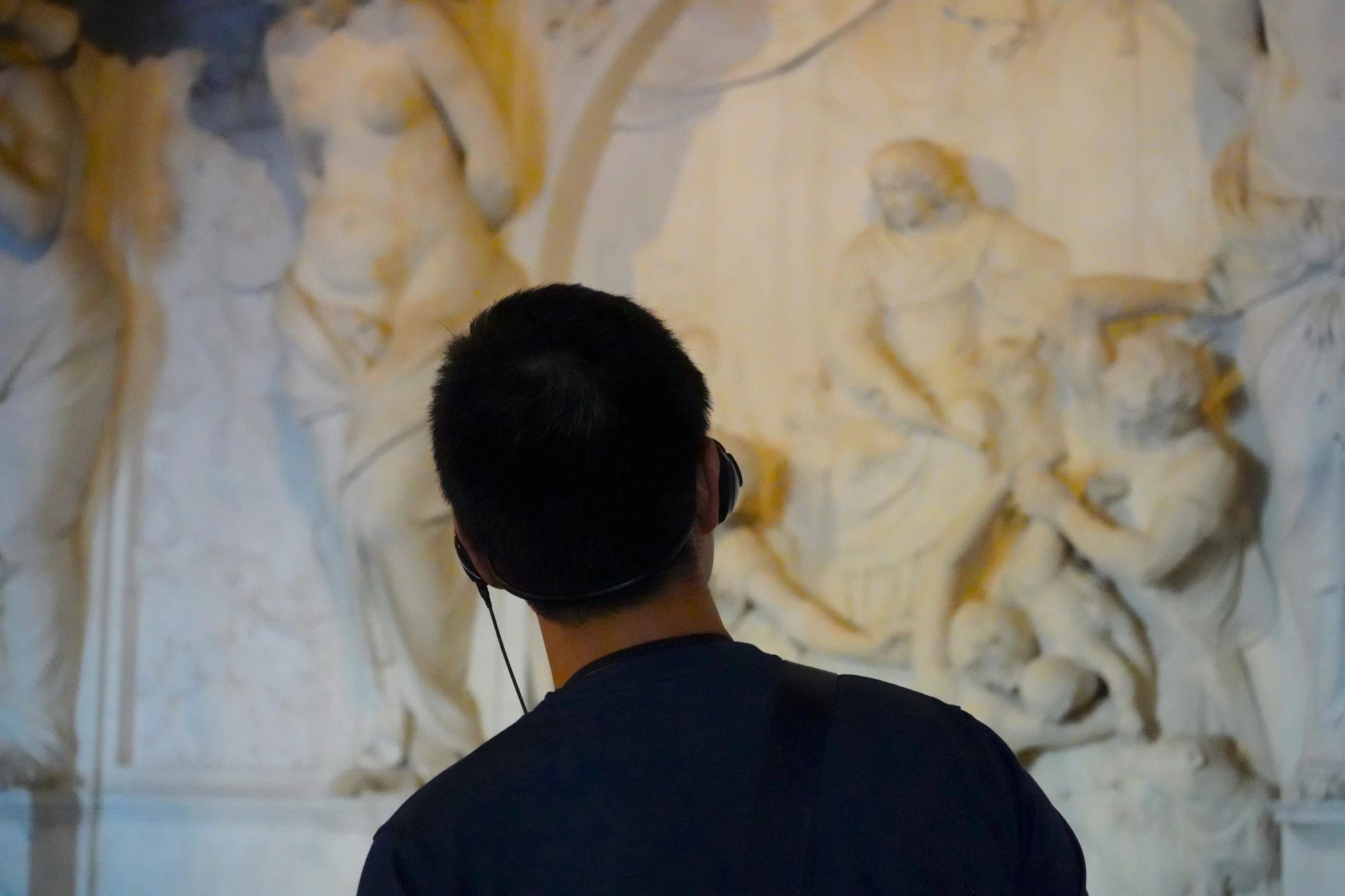 a man standing next to a wall with different carvings