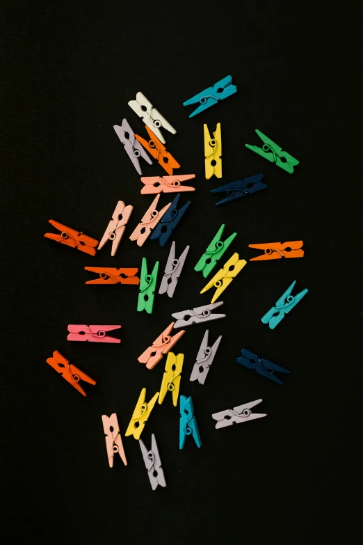 several pairs of colored scissors on top of a black surface