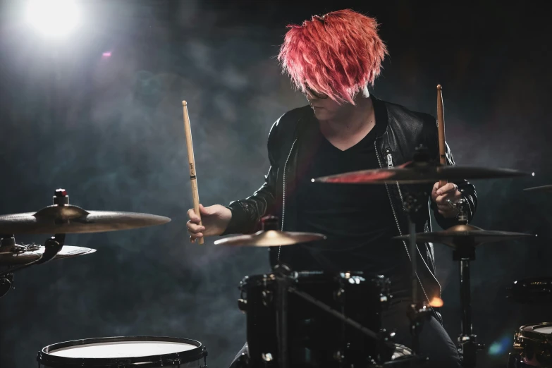 a man with bright red hair playing drums