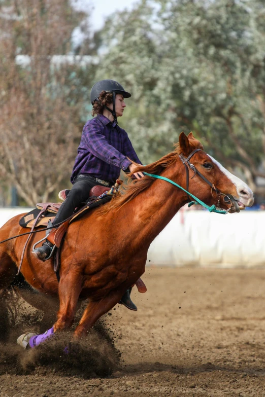 a jockey rides her horse in the dirt