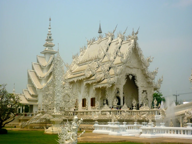 an ornate building in the middle of some green trees