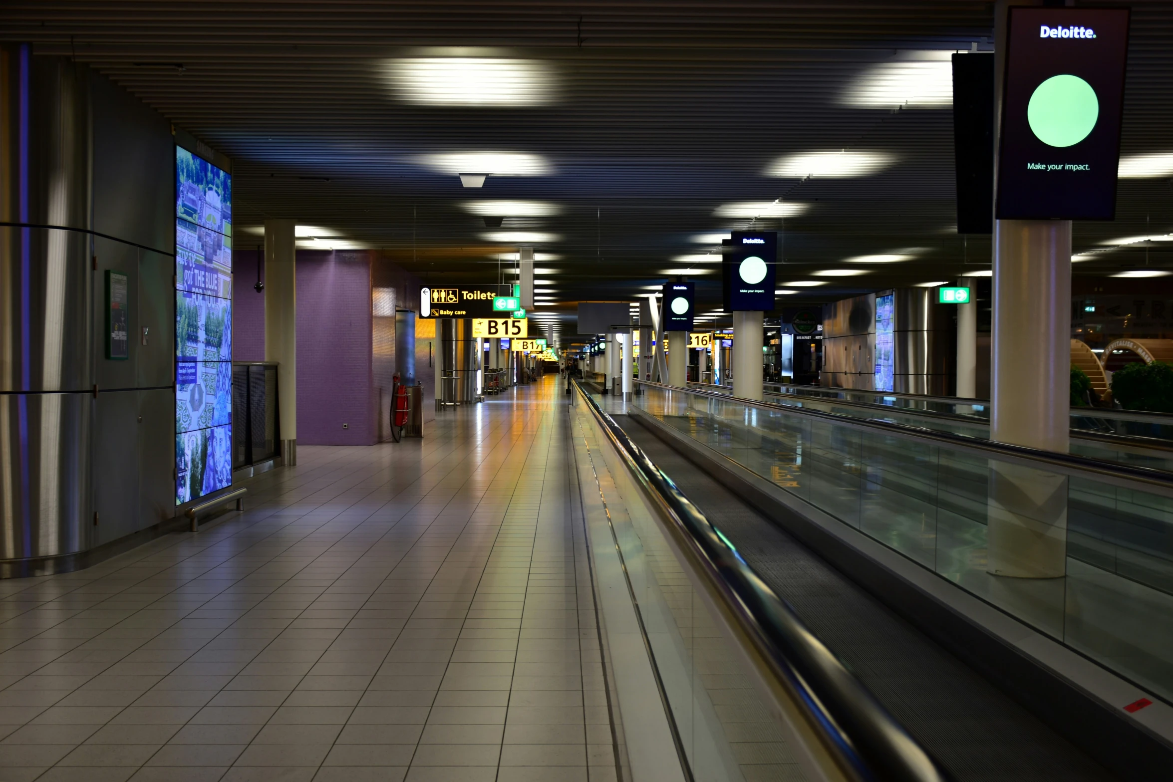 an empty hallway with lots of lights at night