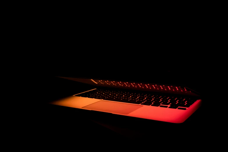 a laptop computer lit up in the dark