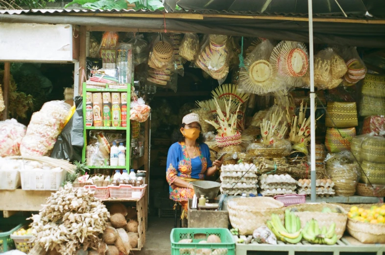 a lady sits behind a produce stand