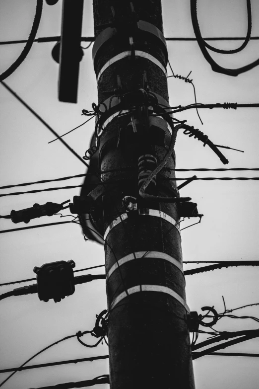 black and white po of electric lines with sky in background