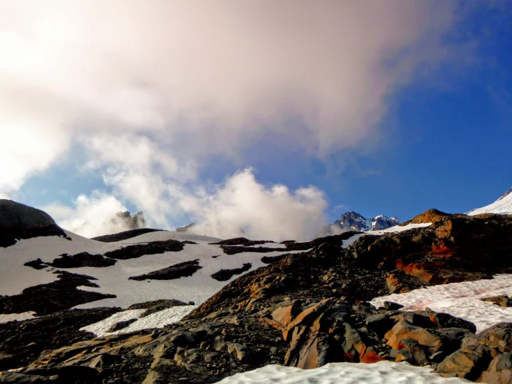 the mountain slope is covered with snow and rocks