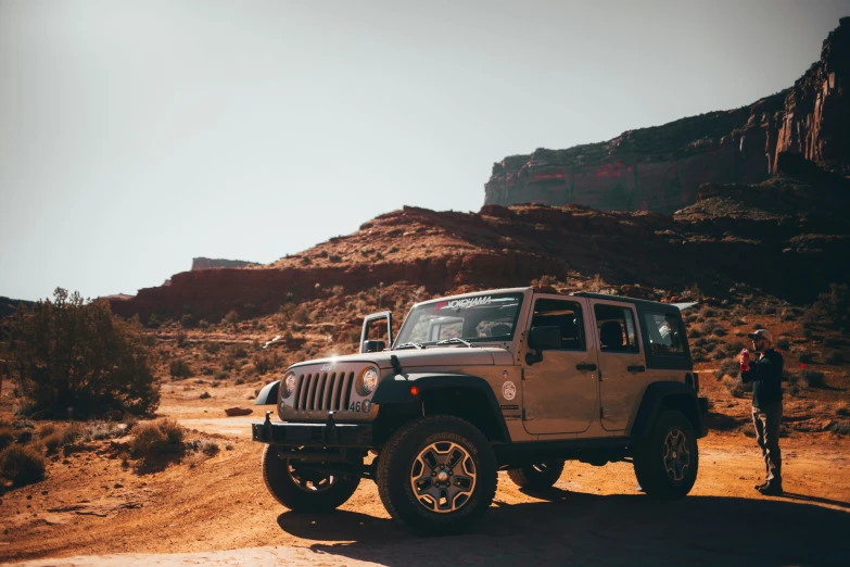 a person standing in front of a white jeep