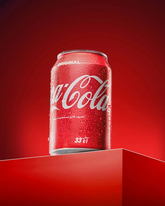 a can of coke is on top of a red surface