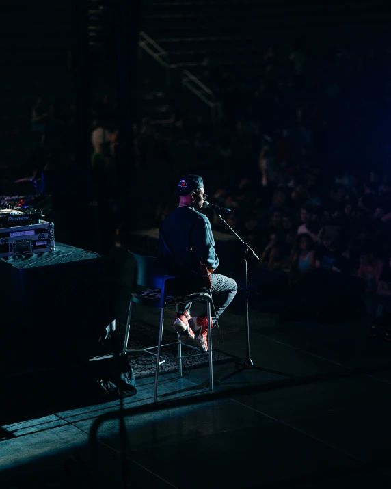 a man is on stage at night while holding a microphone