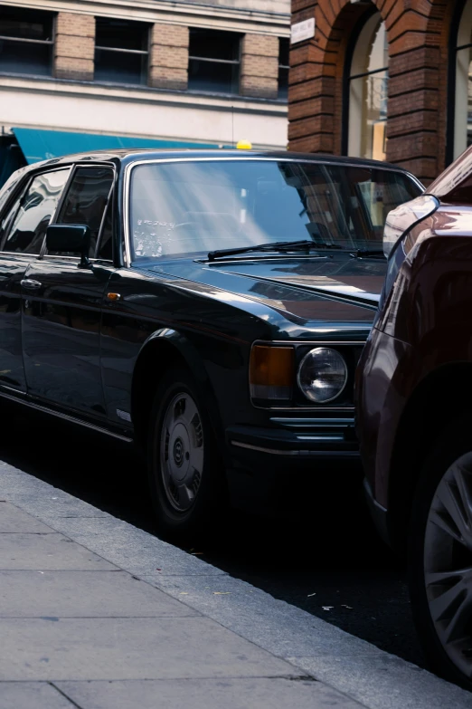 an older and newer bmw coupe are parked side by side