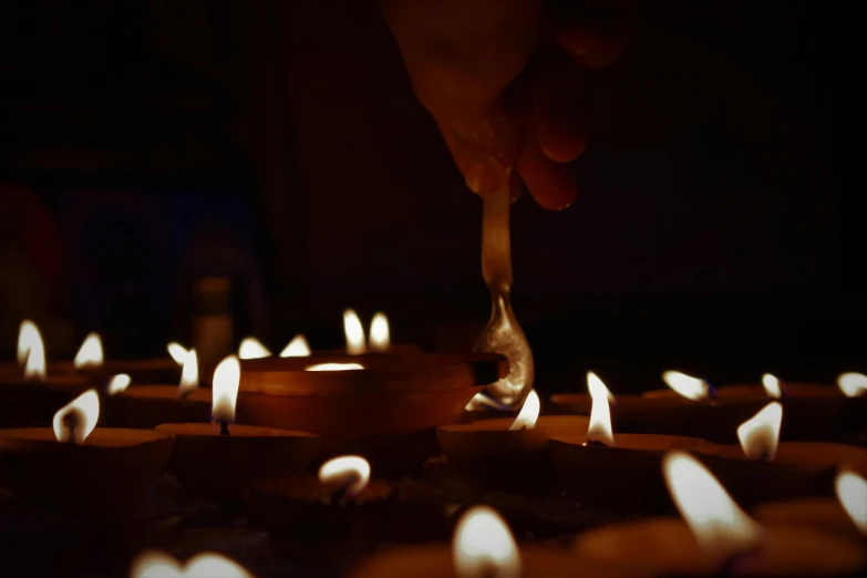 a person lighting up candles in a room filled with others