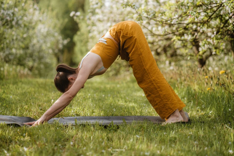 a woman in yellow and white pants doing yoga