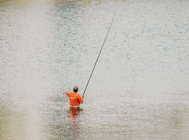 the man is standing in the water fishing