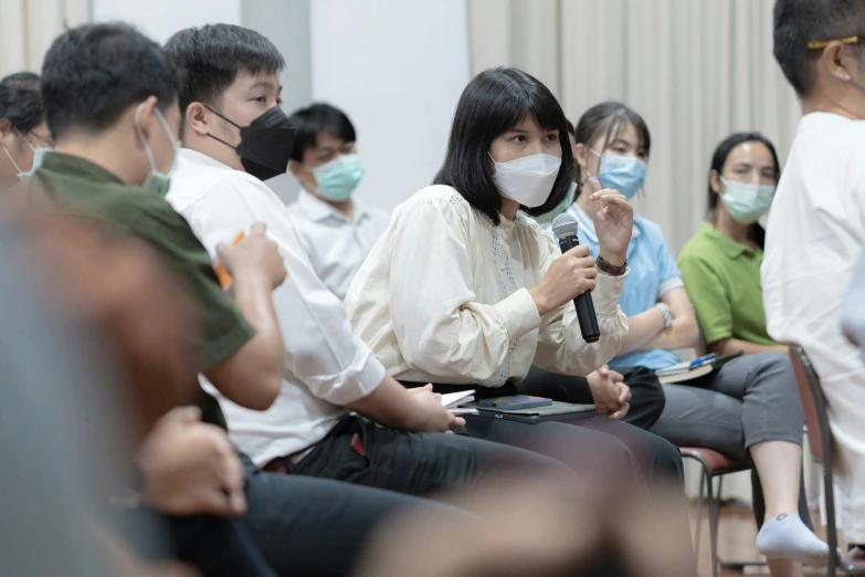 a group of students sit at their desks while wearing face masks