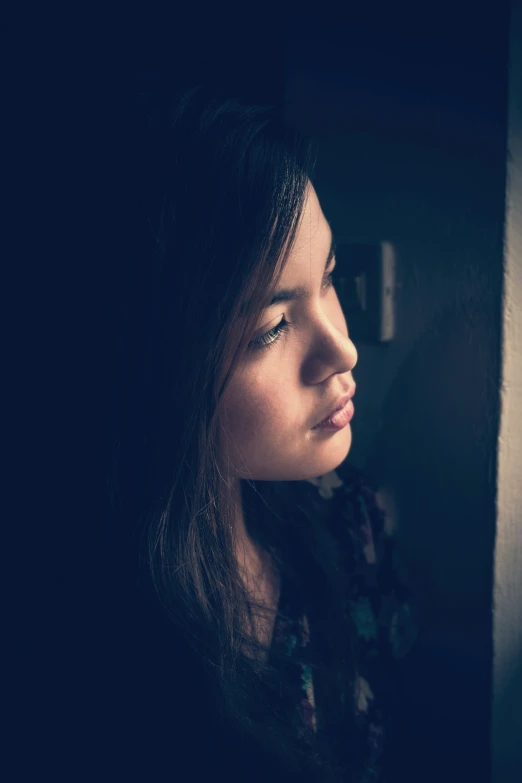 a young lady looking out of a window at soing