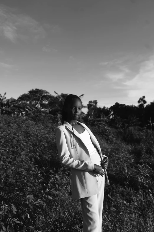 woman in dress standing in the middle of a field