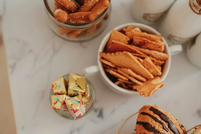 a white marble table with glass jars filled with cookies and ers