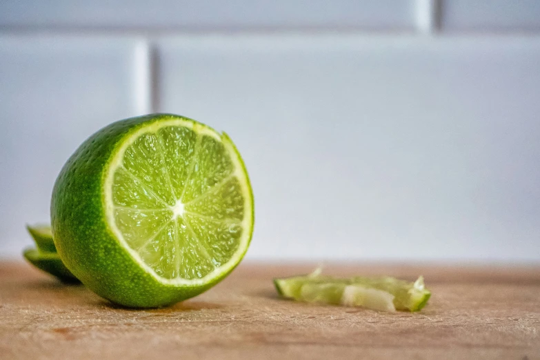 a lime cut in half with a white wall in the background