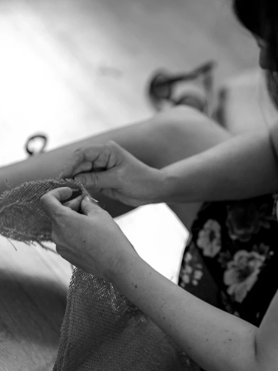 woman in floral shirt using beading to shape material