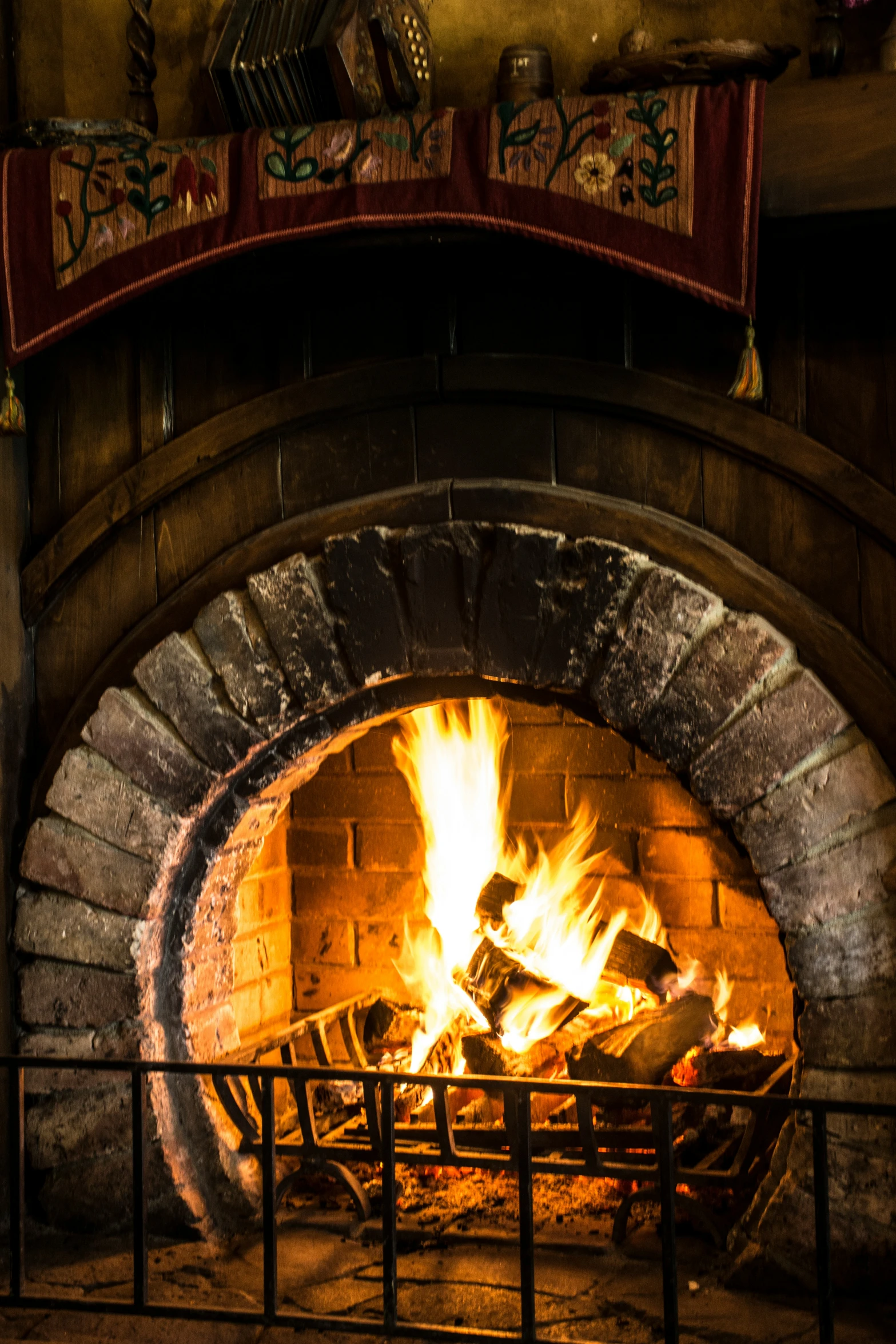 a stone fireplace burning in it's hearth filled with logs