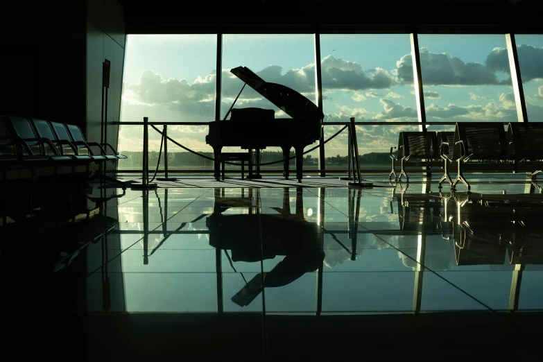 a person is standing by the window with an upright grand piano