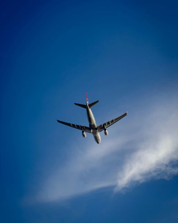 an airplane in the blue sky with a cloud formation