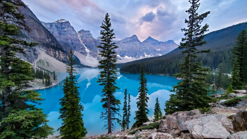 a blue lake and mountains are featured during sunset