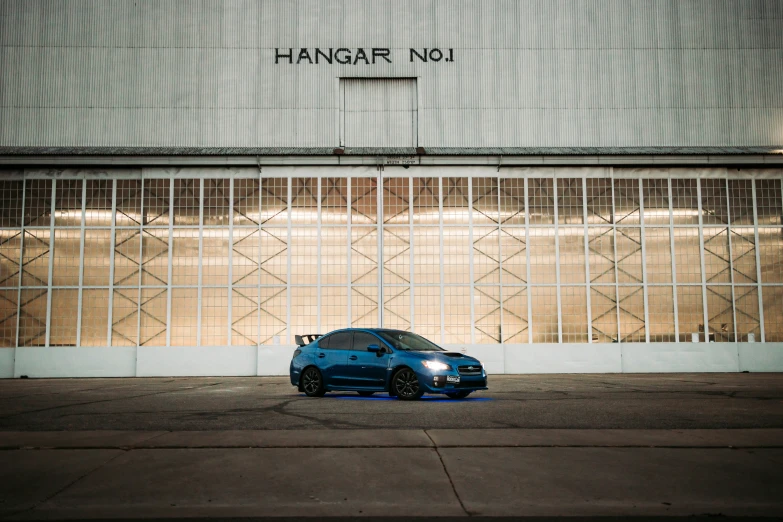 a blue sports car parked near a window on the ground