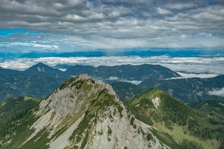 the view from the top of a mountain shows the green hills and clouds