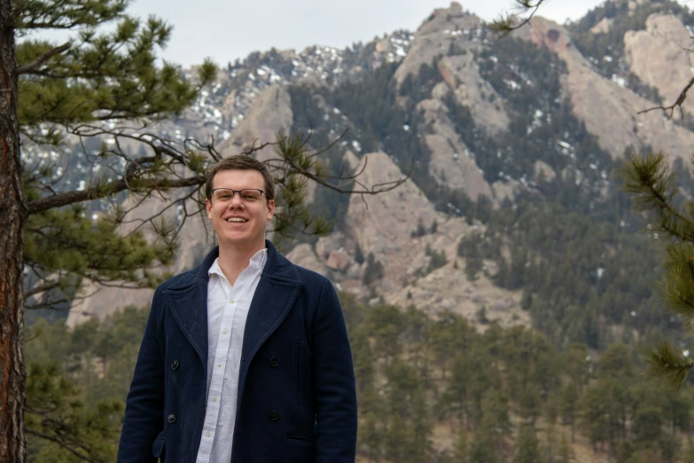 a man standing in front of mountain scenery