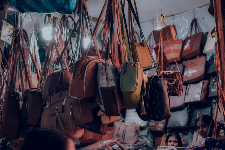 many brown bags hanging up and on a wall