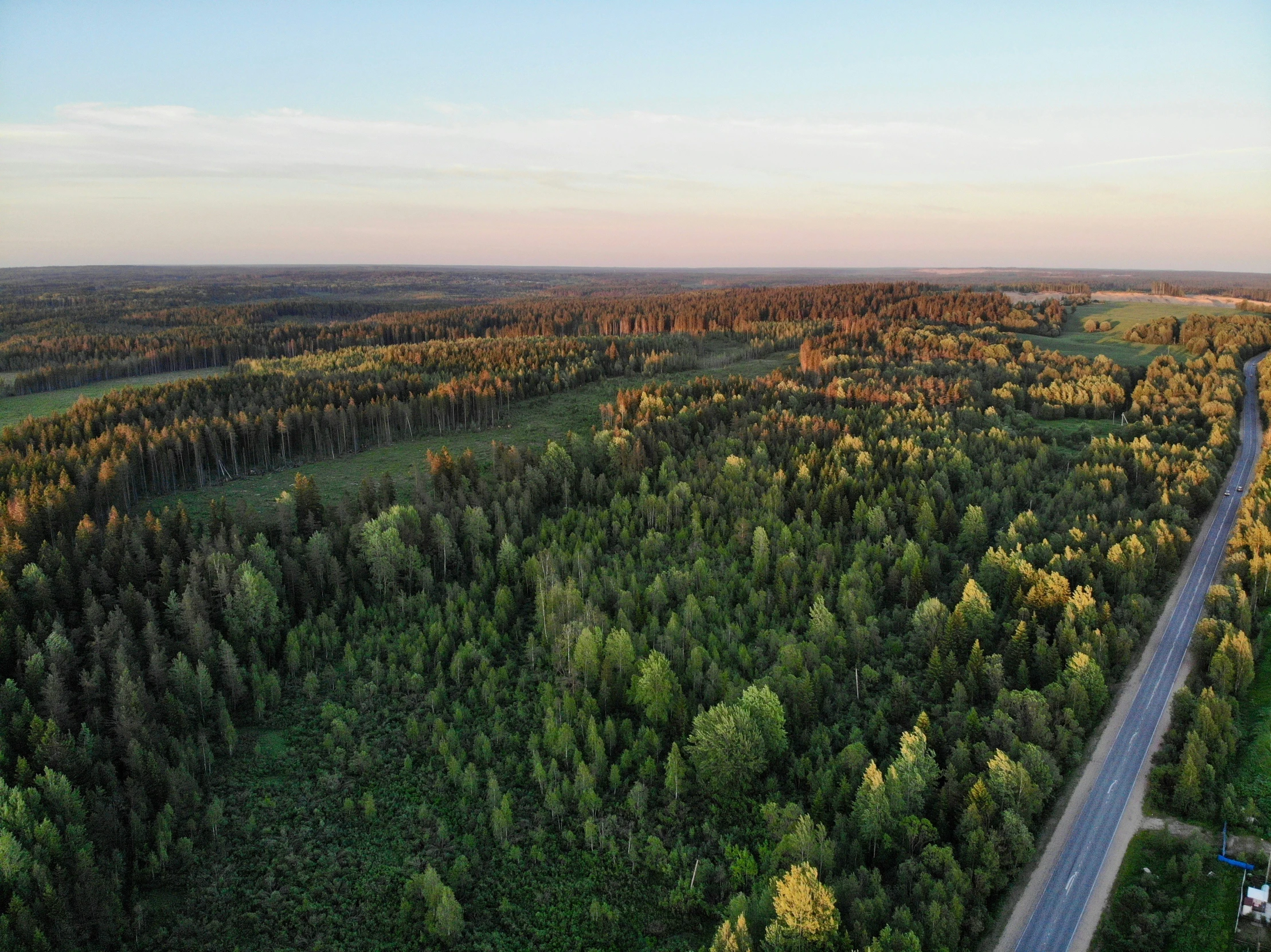 a wide road winds through an expansive country side