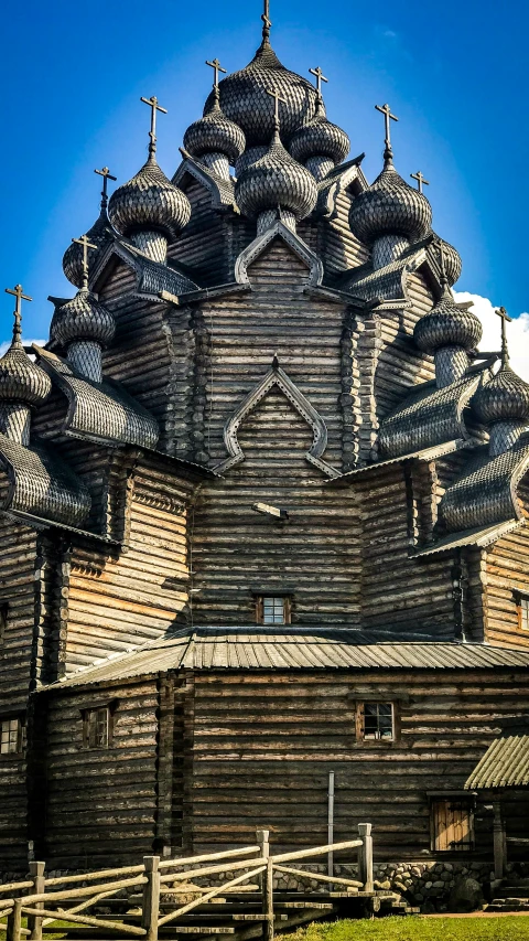 a wooden building with many spires has clocks on it