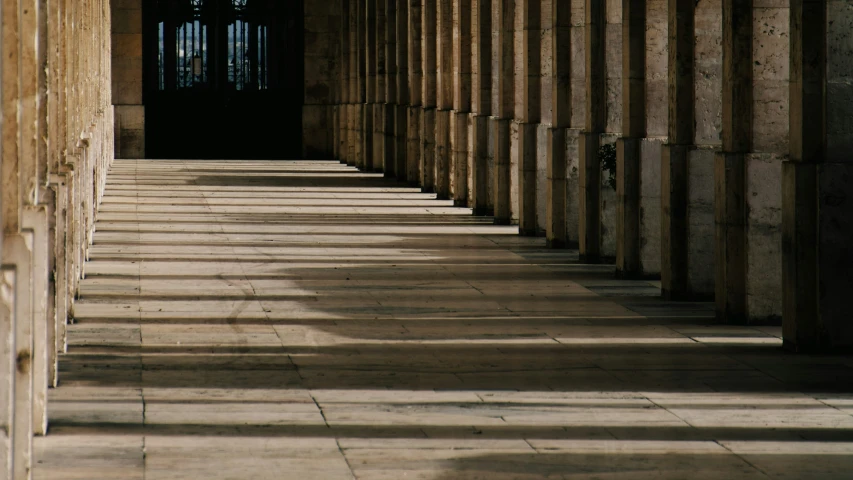 some pillars line a hallway in the middle of a building