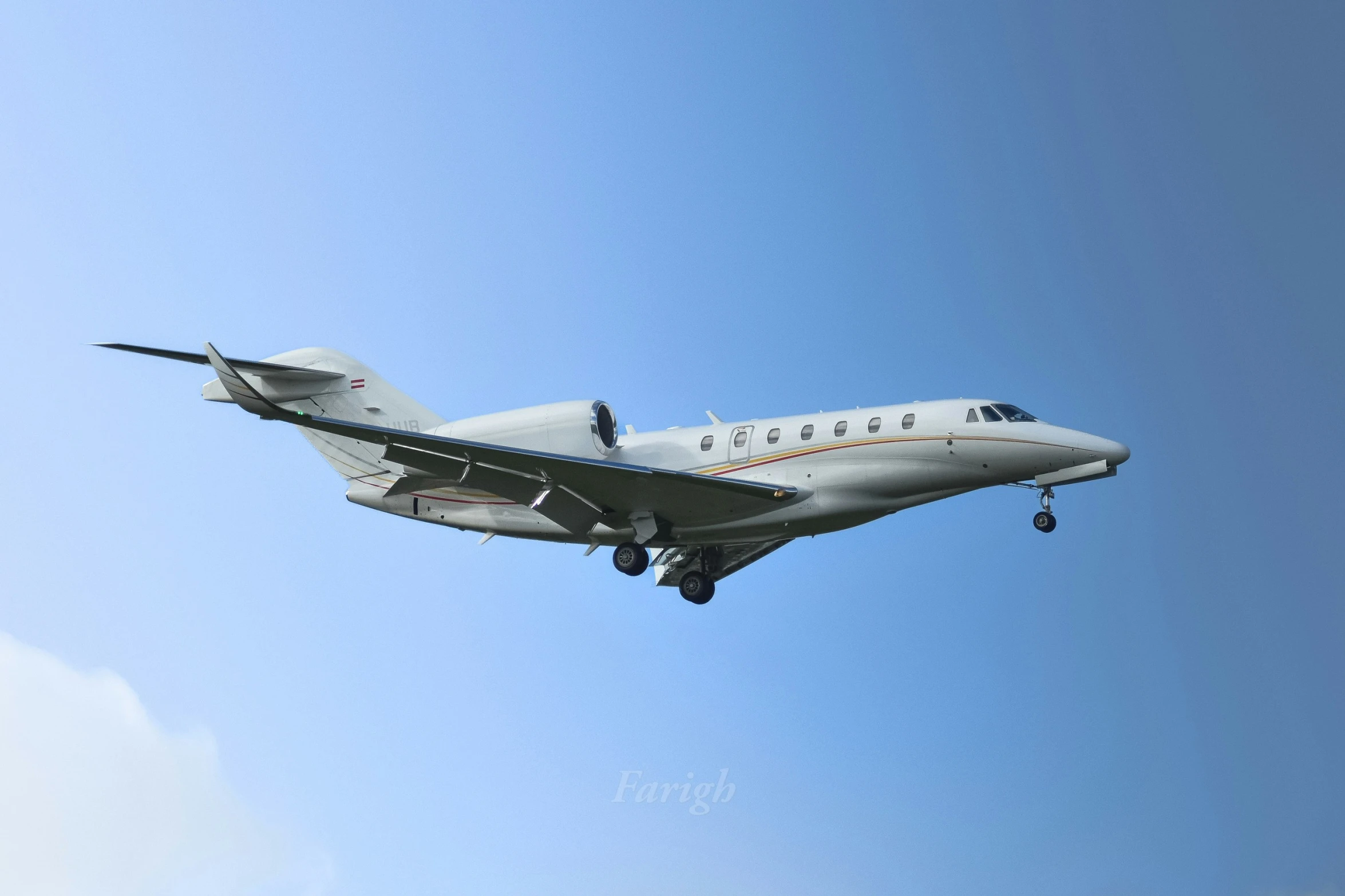 a small plane flying through the blue sky