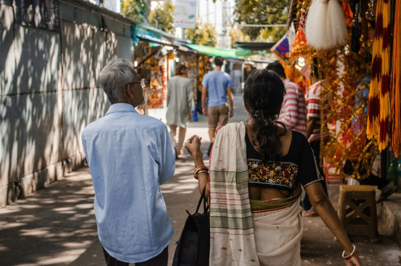 some people and their items for sale in an area with stone walls