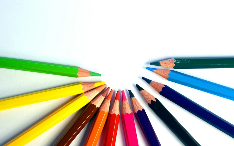 there are a group of different colored pencils on a table