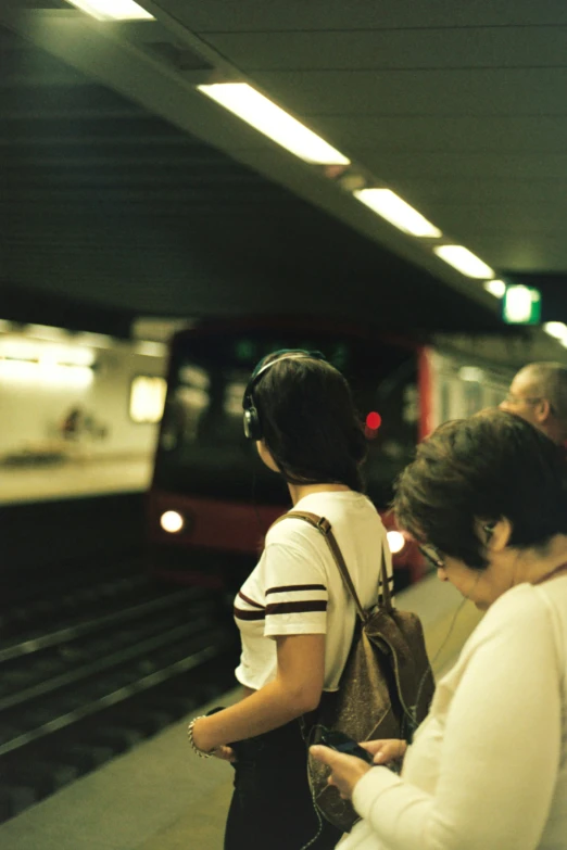 a couple people waiting to get on the subway