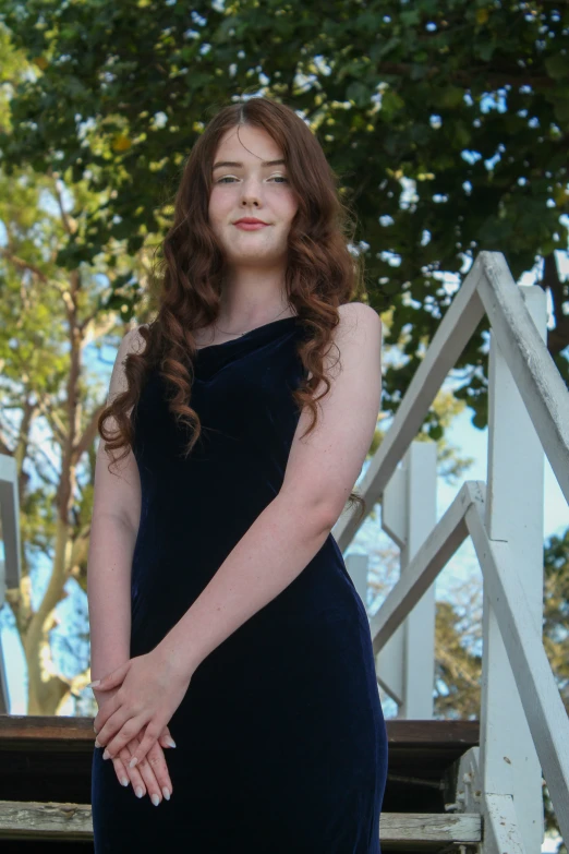 a woman with long red hair is standing on stairs