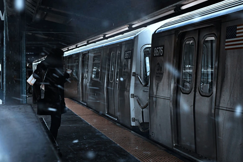 a woman in black is walking near a train