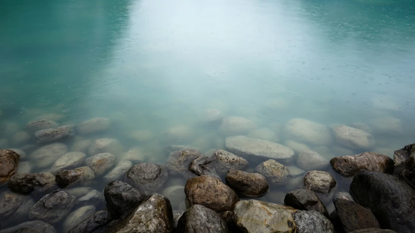 large rocks are in the water near the beach