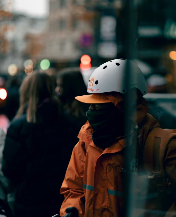 the man in an orange jacket is wearing a helmet