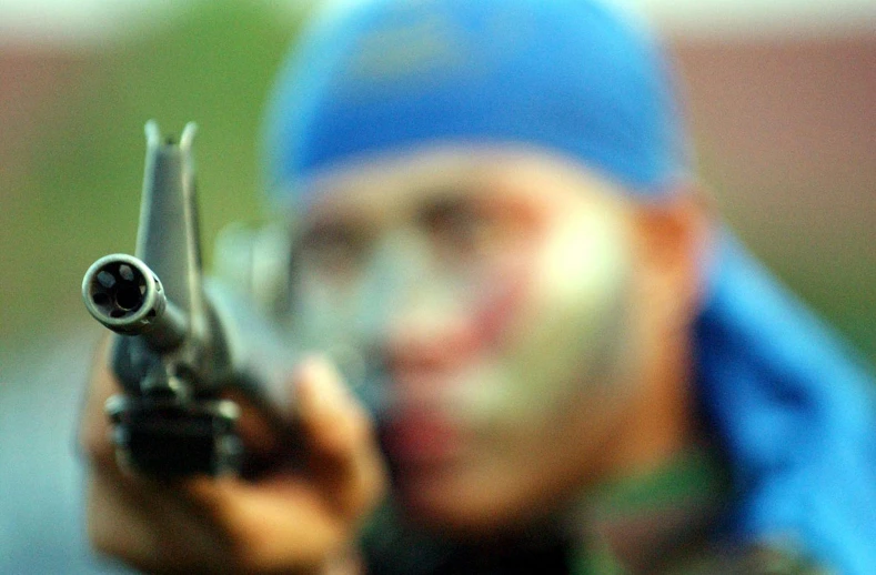 a man holding up a gun to the camera