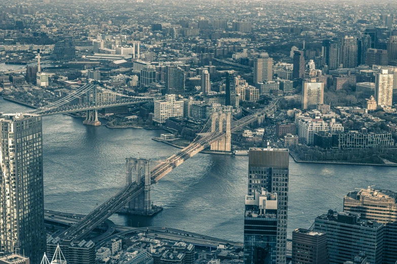 a large city with tall buildings and the bridge across the water