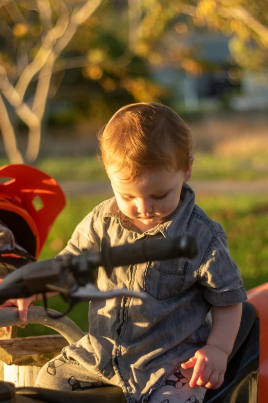 a little boy is sitting on a motorbike