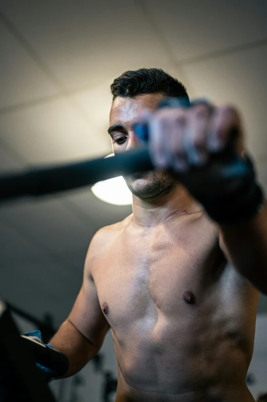 the shirtless man is holding his gym equipment