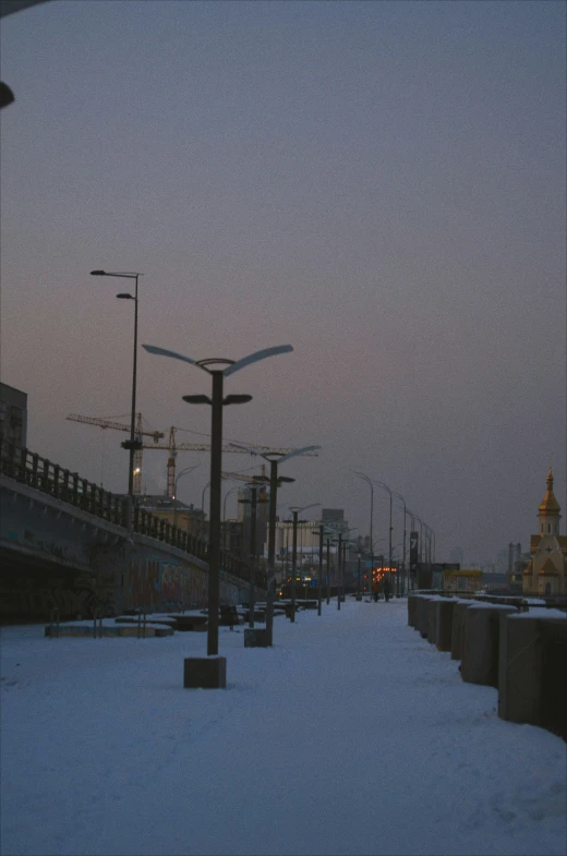 a street in the snow covered area at twilight