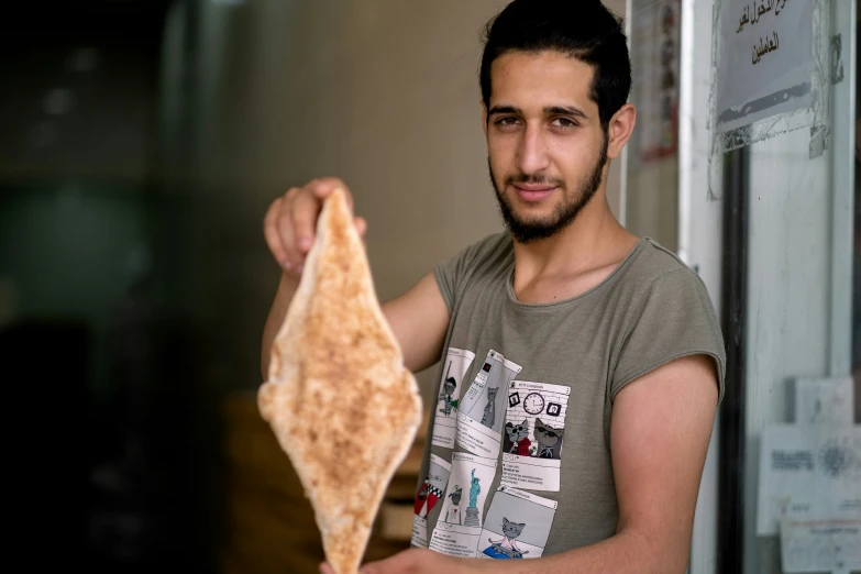 a man is holding a piece of bread