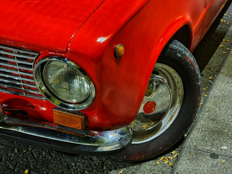 the old vintage automobile is red and has black rims