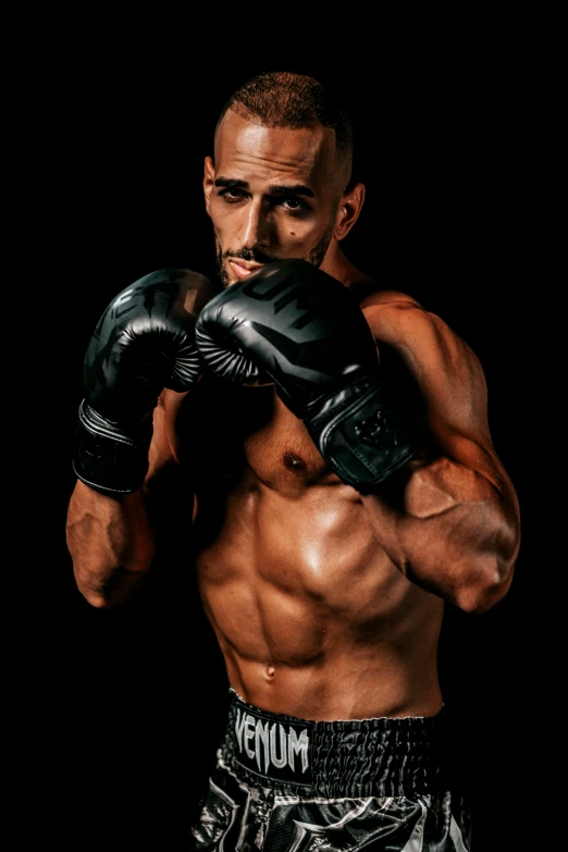 a muscular man is holding his gloves in front of his face